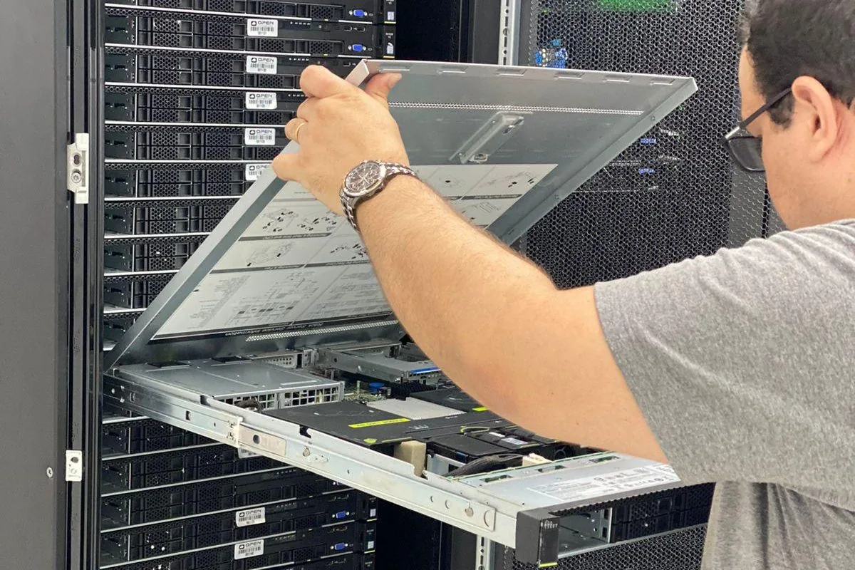 Técnico da OPEN manuseando um servidor no rack