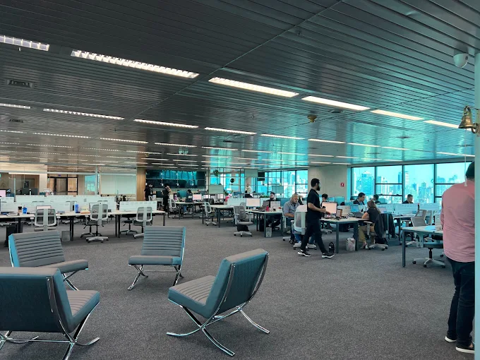 Equipe da OPEN Datacenter trabalhando no escritório em open space, com vista para a cidade